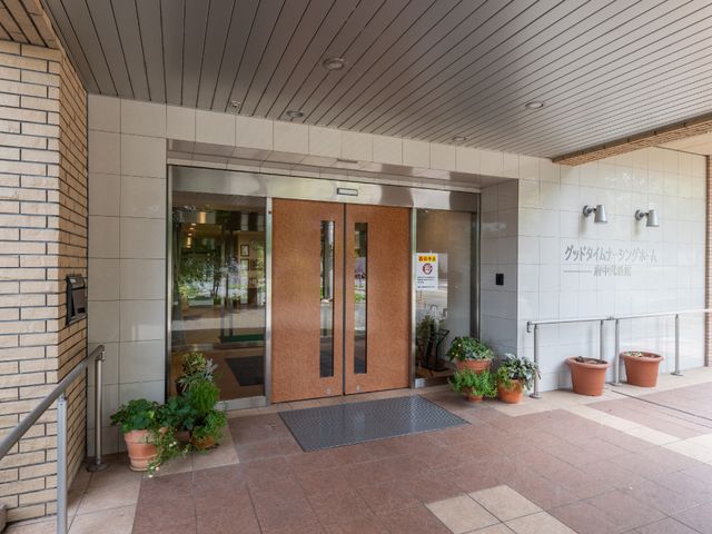 エントランスの明るい風景 玄関 手入れされた植物と落ち着いた色合いのエントランスが迎えてくれます。訪れる方々に安らぎを提供する空間です。