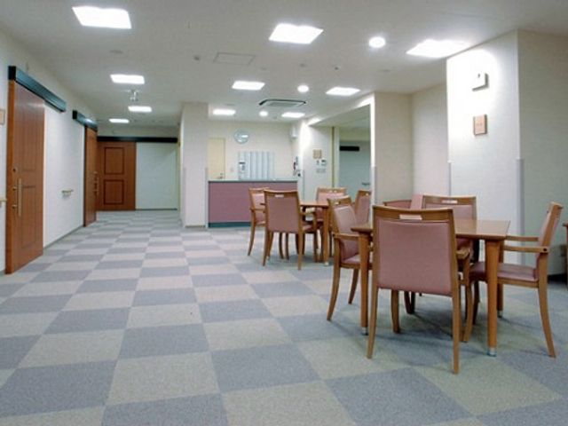 明るい共用スペース 談話ルーム 広々とした清潔な食堂で、ご利用者様がゆったりとお食事をお楽しみになれる環境です。テーブルも配置に余裕があり、快適な空間を提供しています。
