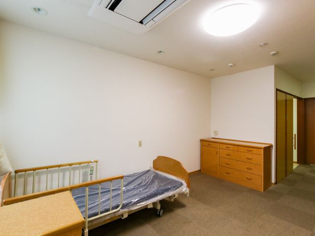 広々とした明るい居室 居室 ゆったりとした空間の居室です。床には滑りにくいカーペットが敷かれ、安全かつ清潔な環境が保たれています。