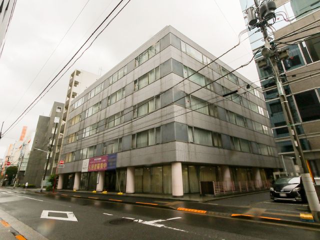 都市のコンクリート建物 外観 都会の風景に溶け込むモダンな建物で、清潔感が漂う外壁が特徴です。働く場所の永続的な印象を与えます。
