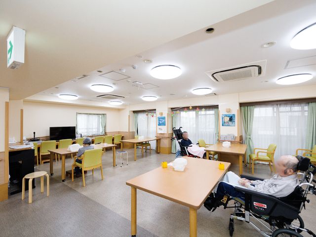 明るい共有スペースの居室 共有スペース 広々とした食堂は、居心地の良い照明と座席配置で、訪れる方々が交流を楽しむ憩いの場です。