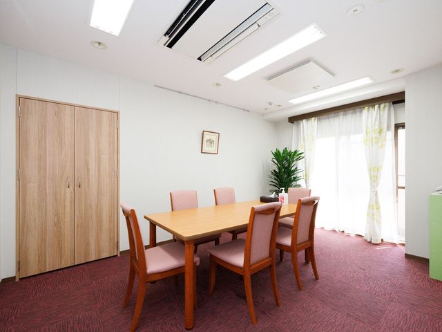 暖かみのある休憩室 談話室 居心地の良い休憩室は、落ち着いた色合いで統一されており、ゆったりと過ごすことができます。窓際の明るい光は、日々のくつろぎの時間をより豊かなものにしてくれます。