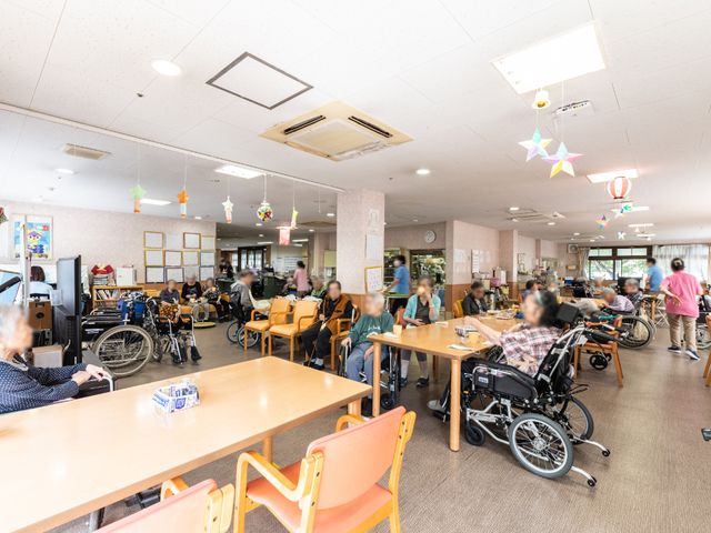 明るい食堂の風景 共有スペース 広々とした明るい食堂の様子です。利用者の方々が食事や会話を楽しんでおられる様子がうかがえます。