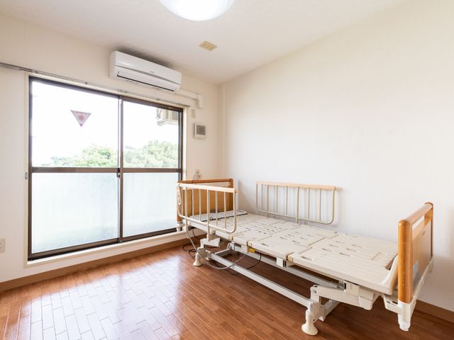快適な居室内観 居室 広々とした室内には、日当たりの良い窓と使いやすい介護ベッドが備えられ、落ち着いた生活空間を提供しています。