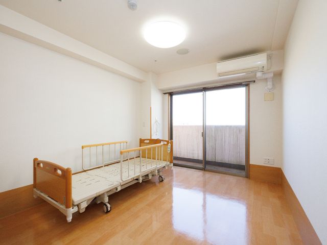 明るい居室の様子 居室 広々とした居室は、清潔感があり木の温もりを感じるフロアで、居心地の良い空間を提供しています。大きな窓からは自然光が差し込み、開放感があります。