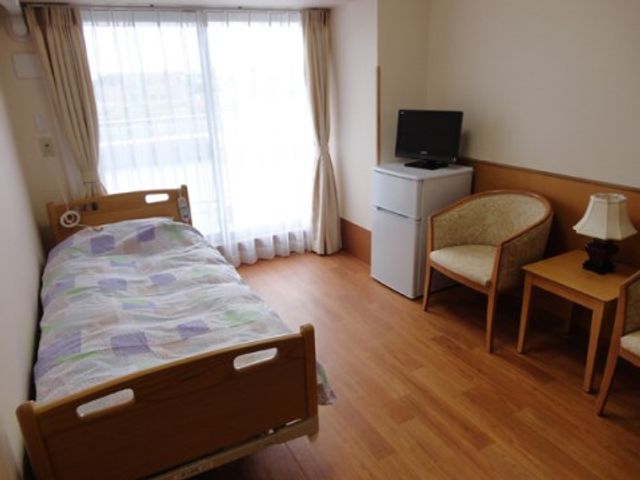 居室の一角 居室 落ち着いた色合いの個室で、窓からの光が心地よい空間をつくり出しています。一人ひとりのプライベートを大切にできる設計です。