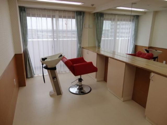 明るい理美容室の空間 サロン ゆったりとした理美容室では、明るい自然光のもとでケアを受けられます。床と家具の色合いが温かみを感じさせ、居心地の良い空間になっています。