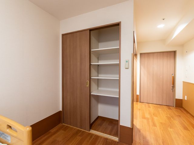 居室内のクローゼットと扉 居室 落ち着いた色調の居室には、衣類や小物をしまえる広々としたクローゼットがあります。スタッフとして利用者様の快適な生活サポートができます。