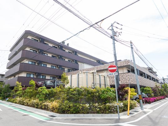 テーブルと手すりが設置された、黒を基調とした介護施設の玄関