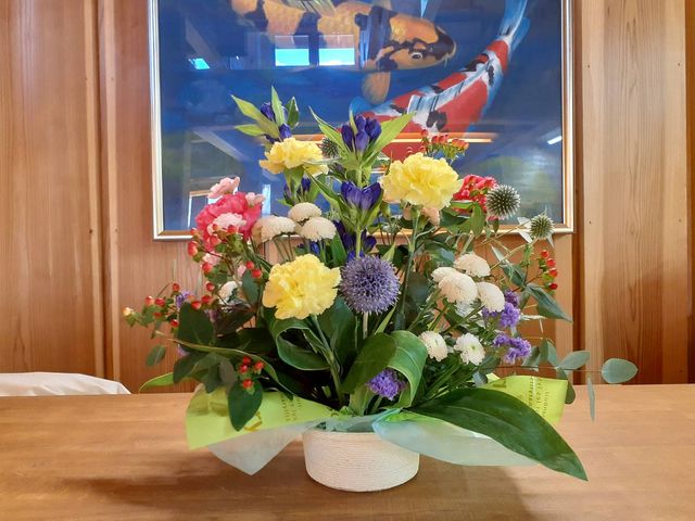 色鮮やかなフラワーアレンジメント 掲示物 心温まるリビングの彩りとして、新鮮なお花をご提供しています。明るい気持ちでお仕事を始められる環境です。