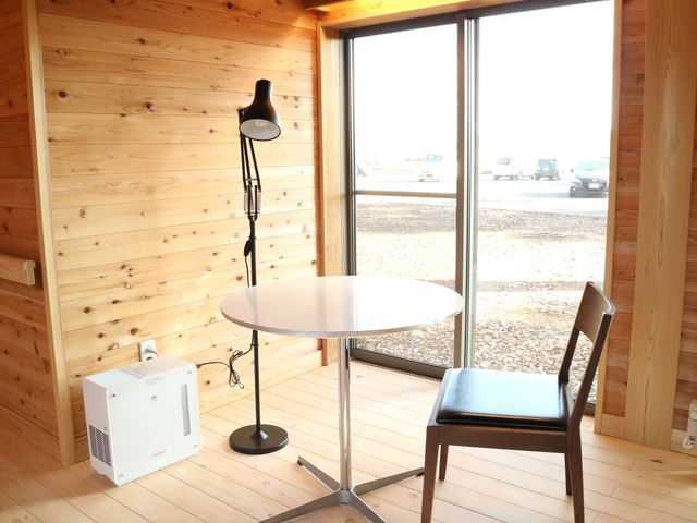 明るい木目の休憩スペース 共有スペース 心安らぐリビングです。窓辺のテーブルで読書やお茶をお楽しみいただけ、快適な時間を過ごせます。