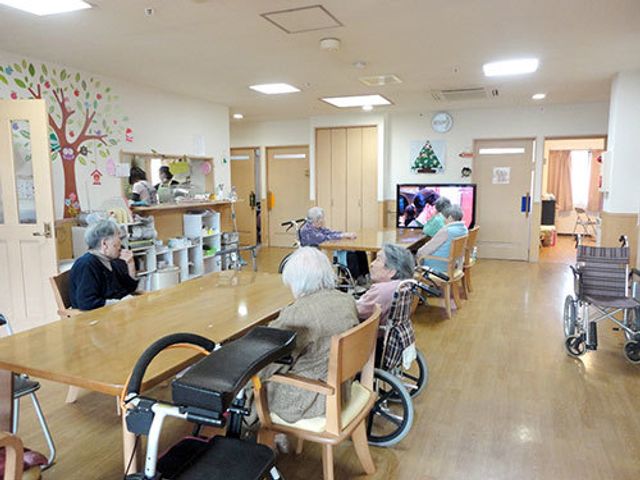 快適なダイニングルーム 共有スペース 温かみのある照明の下、ご利用者が食事やおしゃべりを楽しむダイニングです。広々としたテーブルでは、車椅子の方も安心して過ごせます。