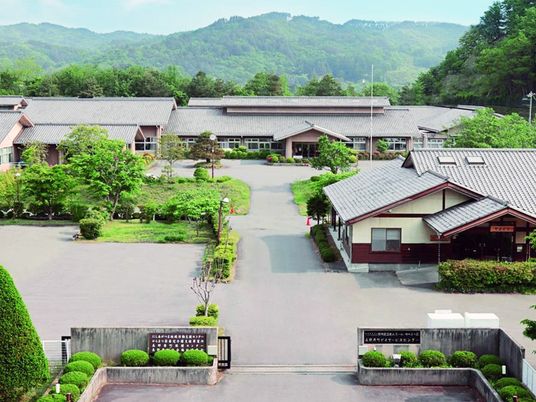 緑に囲まれた施設の外観  