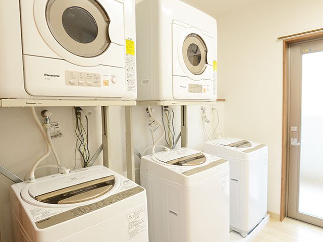 清潔な洗濯室の様子 洗濯室 清潔感のある洗濯スペースには、最新の洗濯機と乾燥機が並び、快適にお使いいただけます。