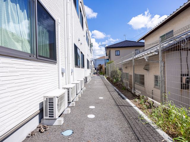 明るく清潔な外観 外観 日差しが降り注ぐ、清潔感あふれる外観です。散策やリラックスに適した小道が見受けられます。