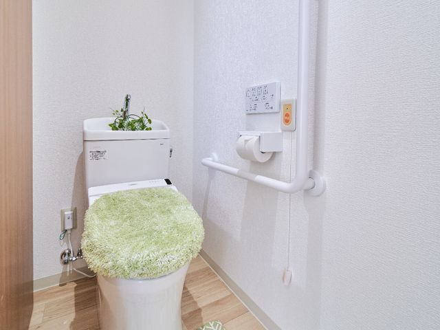 清潔感あるトイレ空間 トイレ 手すりが付いた清潔なトイレは、安心してご利用いただける設計です。利用者の快適さを考えた設備が整っております。