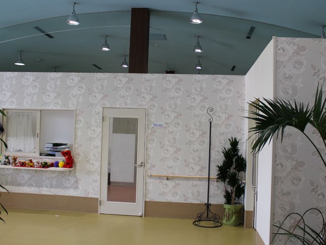 明るい多目的室 多目的室 広々とした空間で、壁には可動式の扉があります。植物が配置され、リラックスした雰囲気です。