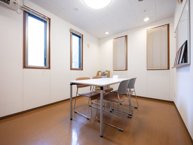 窓付きの多目的室 多目的室   窓から光が入る明るい空間に、テーブルと椅子が配置されています。少人数での打ち合わせや作業に使いやすそうです。
