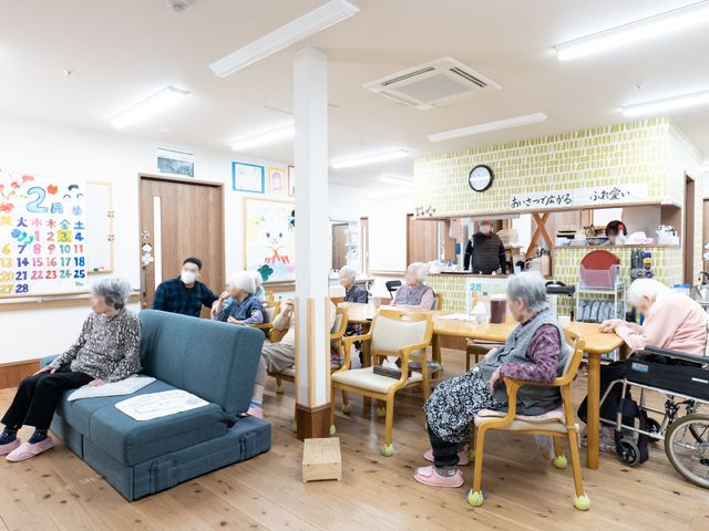 居室でのひととき 共有スペース 広々とした居室で、利用者がリラックスした時間を過ごしており、会話も弾んでいます。自然光が差し込む明るい空間で毎日が快適です。
