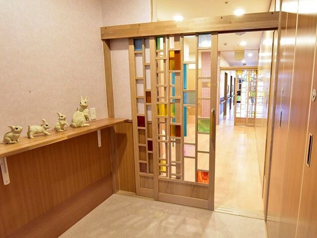 廊下と木製スライドドア エントランス周辺 木製のスライドドアが特徴的な明るい廊下です。素敵な陶器の飾りが訪れる人に温もりを提供しています。