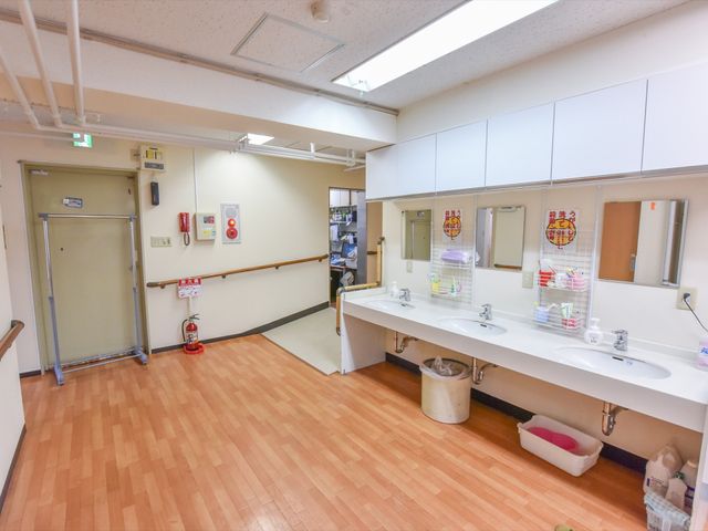 清潔な洗面台と廊下 洗面所 手入れが行き届いた洗面スペースです。こちらでご利用者様の日々の清潔をサポートしています。