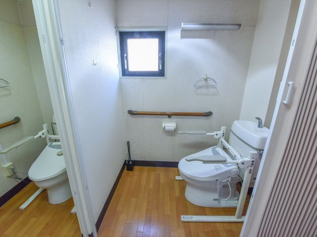バリアフリーのトイレ トイレ 手すりが設置された清潔なトイレは、安全かつ快適にご利用いただける設計になっております。実務経験を積むには最適な環境です。