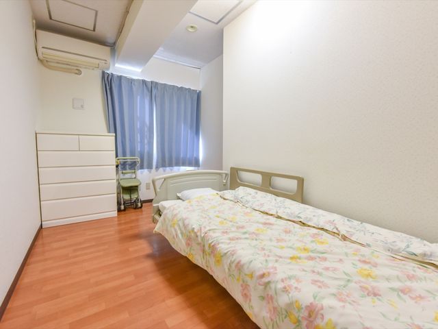 居室の清潔な様子 居室 広々とした個室は落ち着いた色合いで、快適な生活空間を提供しています。適度な収納スペースも完備され、居心地の良さを感じさせます。