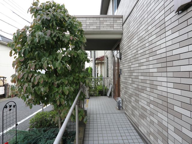 清潔感ある外回り 玄関 ゆったりとした通路には自然光が差し込み、建物の明るさと清潔感が感じられます。