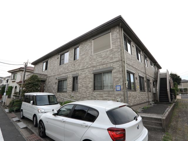 施設外観の建物全体 外観 ゆとりある駐車スペースを備えた落ち着いた色合いの建物です。快適な職場環境をお探しの方に適しています。