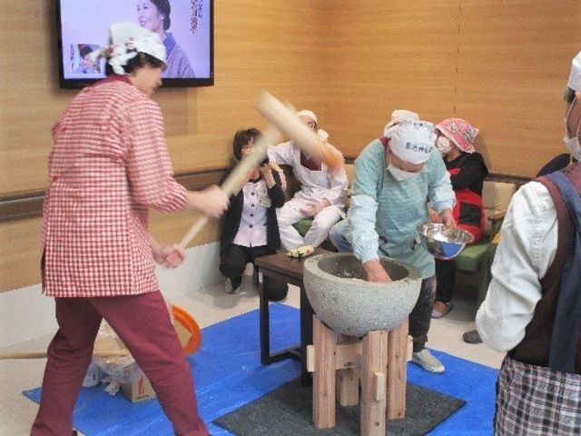 活動するお祭りの様子 通所 施設内の多目的室で行われるイベントの様子です。皆で協力して楽しくお餅つきを行っており、和気あいあいとした雰囲気が伝わります。