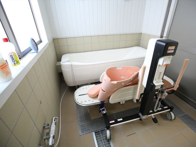 バリアフリー設計の浴室 浴室 利用者の安全を考えた清潔感ある浴室です。手すりやリフトなどが整っており、ケアのしやすさが伺えます。