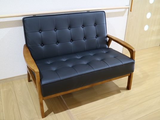 黒いクッションの木製ソファ