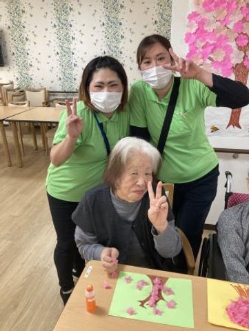 スタッフと利用者の和やかな様子 明るい表情で楽しそうに過ごされるスタッフと利用者の姿。共に創造的な活動に取り組む姿から温かな雰囲気が伝わります。