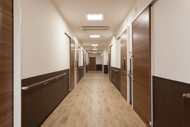 明るい木目調の廊下 廊下 広々とした明るい廊下は、木目調のデザインで落ち着いた雰囲気を作り出しています。