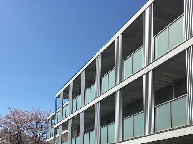 青空の下の建物外観 外観   広々とした窓が並ぶ、開放感のある外観です。利用者の方々に快適な環境を提供しています。