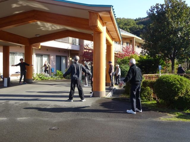 屋外で運動をする様子 外観 日差しが心地よい屋外では、入居者が楽しく体操をしています。リラックスして活動できる環境です。