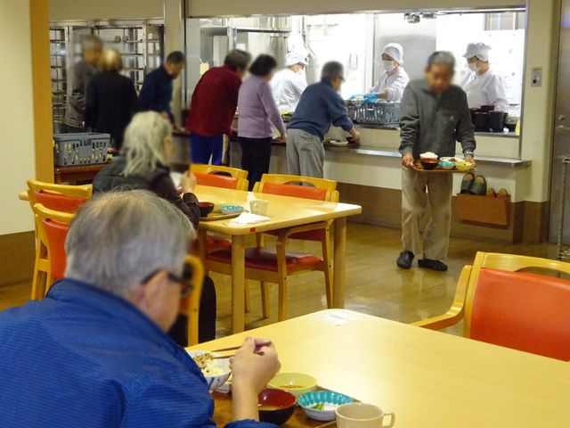 食堂での食事風景 食堂 自然光が差し込む明るい食堂で、利用者の方々が楽しそうに食事をされています。