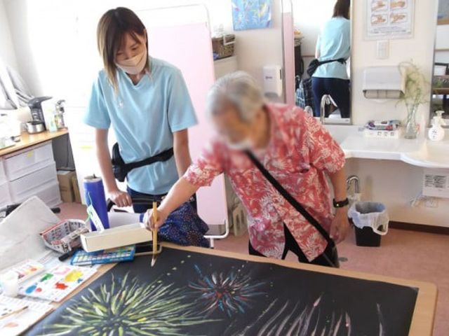 笑顔の絵画活動中の部屋 多目的室 自然光の差し込む明るい空間で、参加者が楽しみながら絵を描いている様子です。