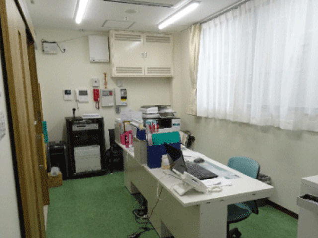 明るい事務室 スタッフイメージ 広々としたオフィスで、明るい自然光が差し込んでいます。スタッフが快適に作業ができます。