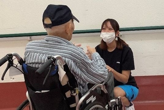車椅子の方と話すスタッフ