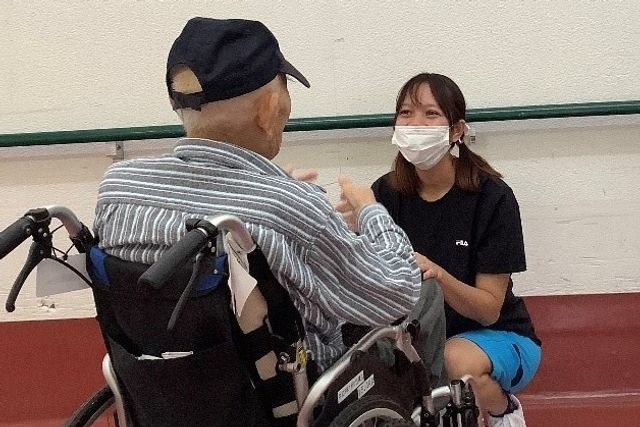 車椅子の方と話すスタッフ