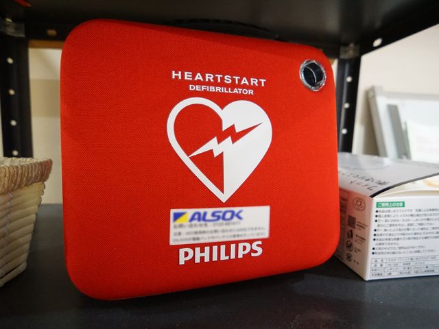 赤いAEDのクローズアップ AED 最新のAEDを備えた安心の環境です。急な体調不良時も対応可能で、安全に配慮した設備が整っています。