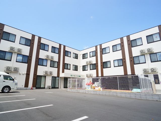 広々とした施設外観 駐車場 広い敷地に立つこの施設では、明るい雰囲気の中で働くことができます。スタッフと利用者のコミュニケーションを大切にしています。