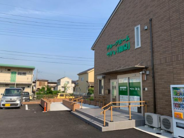 明るい日差しの施設外観 清潔感があり、優しい色合いの建物の入口付近です。バリアフリー設計であるため、すべての方が快適に過ごせる環境が整えられています。
