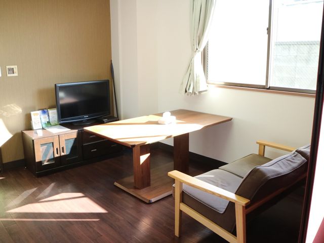 居室内のテーブルと椅子 談話スペース 日差しが心地よい居室です。ゆったりとした椅子でくつろぎながら、テレビをご覧になれます。