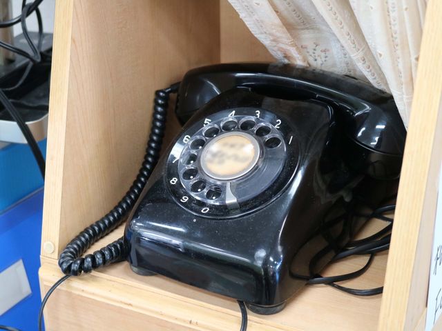 古風な黒電話 黒電話 懐かしいデザインの電話機が置かれ、スタッフの温かみのある接客を思わせます。