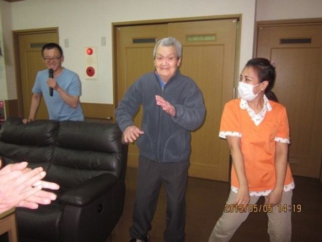 笑顔で体操する高齢者と職員