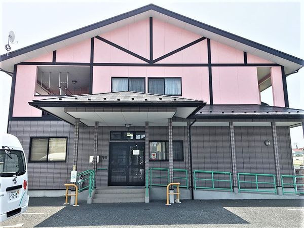 ピンク外壁の建物エントランス