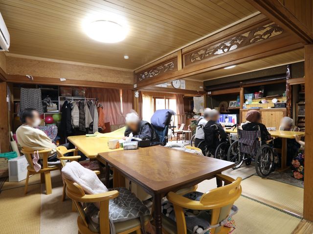 和風共有スペース 談話室 畳に囲まれたアットホームな雰囲気のリビングです。居心地の良さそうな空間で、利用者の方々がくつろいでいらっしゃいます。