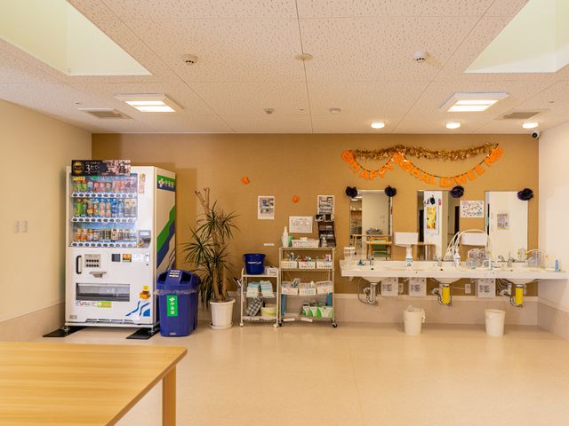 休憩スペースの様子 洗面台 飲み物を手に取りやすい自動販売機が設置された休憩スペースです。暖かい雰囲気の中で、くつろぎ時間を過ごせる環境が整っています。